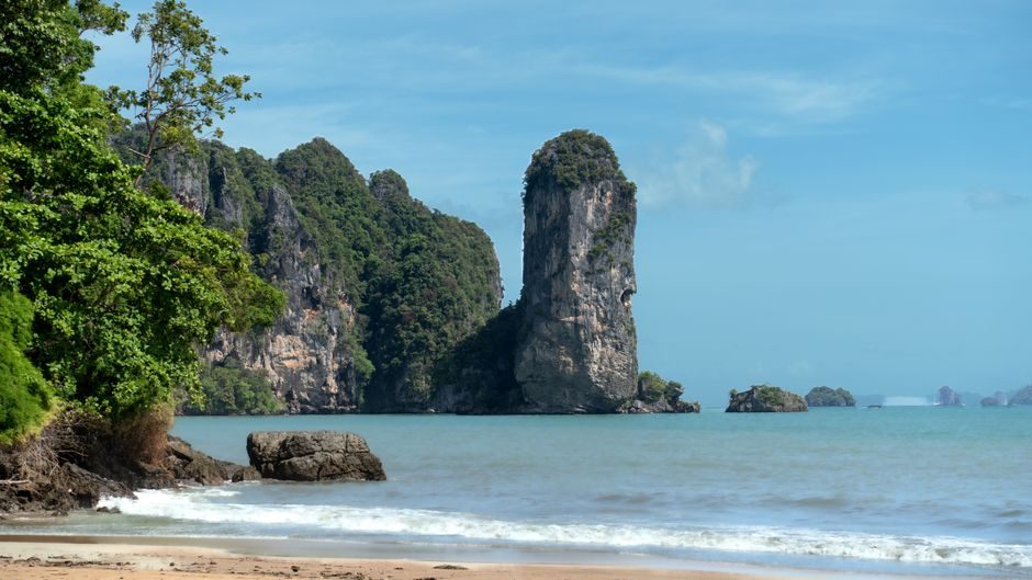 Longtail boats on a Thailand beach with limestone cliffs